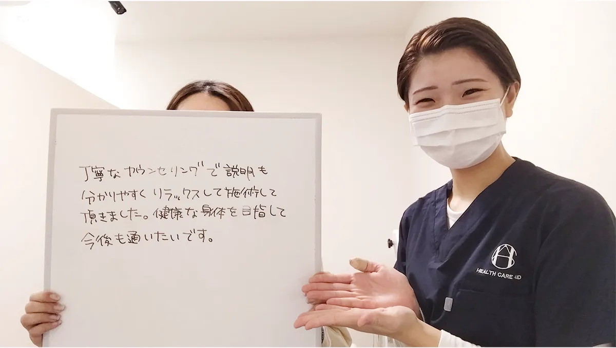 症状が改善した女性と並ぶ整体師